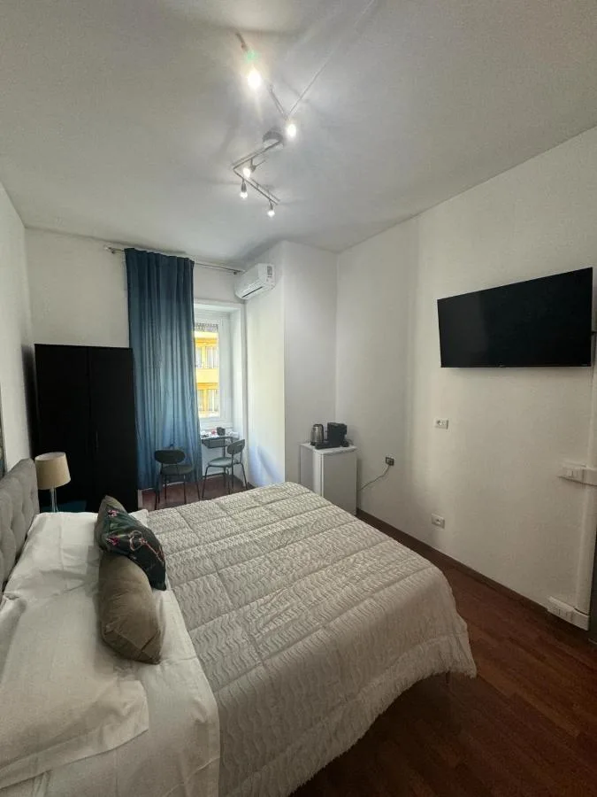 La camera tripla vista dal letto singolo, con il matrimoniale e la TV a parete